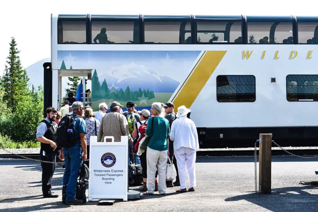 People standing outside a cruise transfer bus